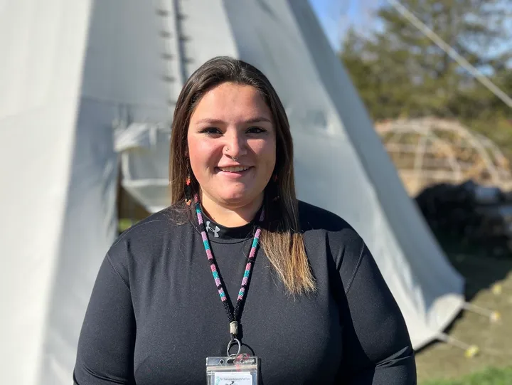 Person standing outside near a teepee.